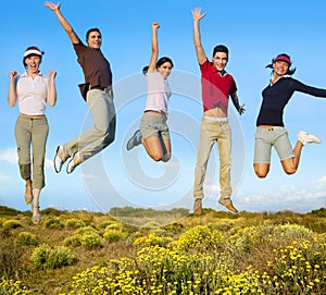 Jumping young people happy group on yellow flowers