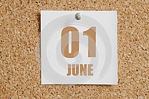 june 01. 01th day of the month, calendar date.White calendar sheet attached to brown cork board.Summer month, day of the