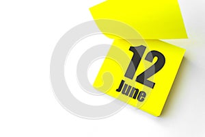 June 12nd. Day 12 of month, Calendar date. Close-Up Blank Yellow paper reminder sticky note on White Background. Summer month, day