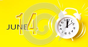 June 14th. Day 14 of month, Calendar date. White alarm clock with calendar day on yellow background. Minimalistic concept of time