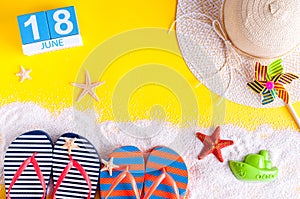 June 18th. Image of june 18 calendar on yellow sandy background with summer beach, traveler outfit and accessories