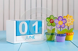 June 1st. Image of june 1 wooden color calendar on blue background with flowers. First summer day. Empty space for text