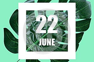 june 22nd. Day 22 of month,Date text in white frame against tropical monstera leaf on green background summer month, day
