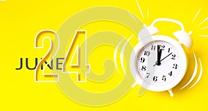 June 24th. Day 24 of month, Calendar date. White alarm clock with calendar day on yellow background. Minimalistic concept of time