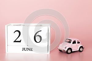 June 26th. Day 26 of month. Calendar cube on modern pink background with car