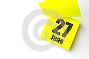 June 27th. Day 27 of month, Calendar date. Close-Up Blank Yellow paper reminder sticky note on White Background. Summer month, day