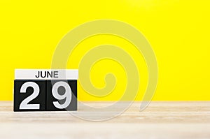 June 29th. Day 29 of month, calendar on yellow background. Summer day. Empty space for text