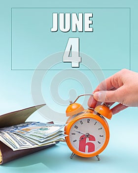 June 4th. Hand holding an orange alarm clock, a wallet with cash and a calendar date. Day 4 of month.