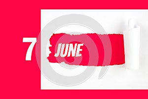 June 7th. Day 7 of month, Calendar date. Red Hole in the white paper with torn sides with calendar date. Summer month, day of the