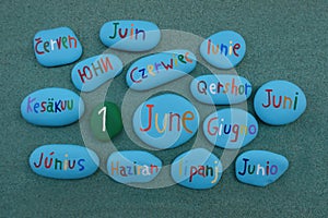 1 June on colored stones in many languages over green sand photo
