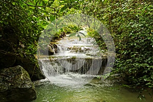 Jungle landscape with flowing turquoise water of Erawan cascade waterfall