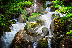 Jungle landscape with flowing turquoise water of georgian cascade waterfall at deep green forest. Mountain of georgia