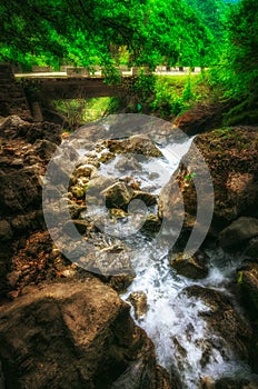 Jungle landscape with flowing turquoise water of georgian cascade waterfall at deep green forest. Mountain of georgia