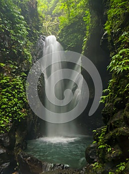 Jungle landscape with flowing turquoise water of waterfall at deep tropical rain forest.
