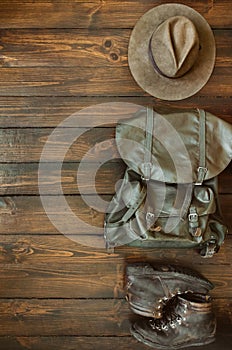 Jungle tropical forest, mountains hiking stuff arranged on wooden floor. Backpack, hat, boots. Safari concept. Empty space for