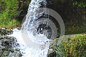 Jungle waterfall cascade in tropical rainforest with rock and turquoise blue pond.