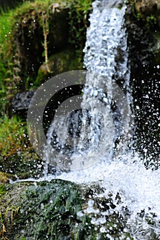 Jungle waterfall cascade in tropical rainforest with rock and turquoise blue pond.