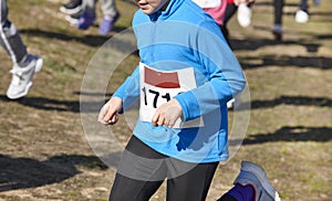 Junior athletic runner on a cross country race. Outdoor circuit