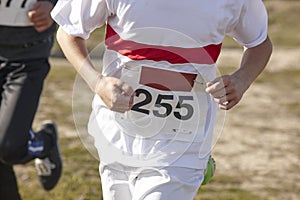 Junior athletic runner on a cross country race. Outdoor circuit