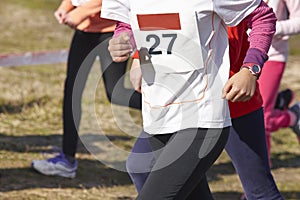 Junior athletic runners on a cross country race. Outdoor circuit