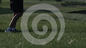 Junior golfer playing golf on summer with hitting shot on green grass