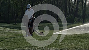 Junior golfer playing golf on summer with hitting shot on green grass