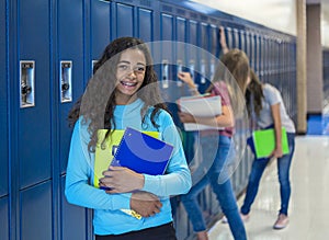 Junior High school Student standing by her locker in a school hallway photo