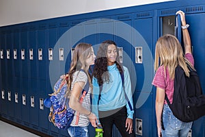 Junior High school Students talking and standing by their locker in a school hallway