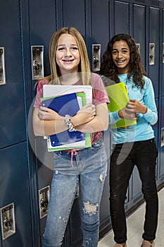 Junior High school Students talking and standing by their locker in a school hallway