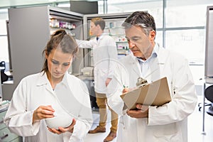 Junior pharmacist mixing a medicine being supervised