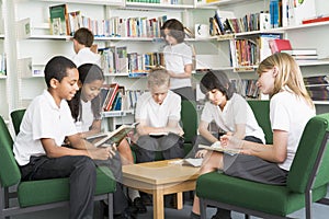 Junior school students working in a library photo