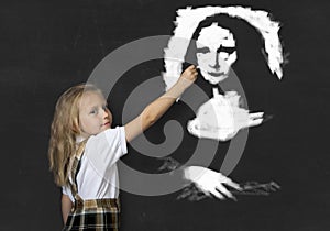 Junior schoolgirl with blonde hair drawing and painting with chalk La Gioconda amazing replica photo