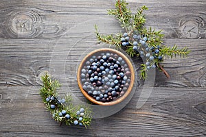 Juniper berries in a bowl with a sprig