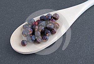 Juniper berries in a wood spoon