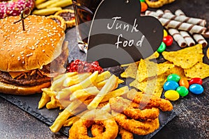 Junk food concept. Unhealthy food background. Fast food and sugar. Burger, sweets, chips, chocolate, donuts, soda photo