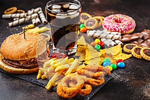 Junk food concept. Unhealthy food background. Fast food and sugar. Burger, sweets, chips, chocolate, donuts, soda