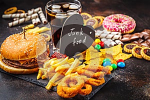 Junk food concept. Unhealthy food background. Fast food and sugar. Burger, sweets, chips, chocolate, donuts, soda