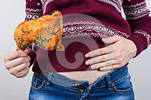 Junk food eating too much concept. Cropped close up photo of girl holding hands palm on big full abdomen feeling heartburn after