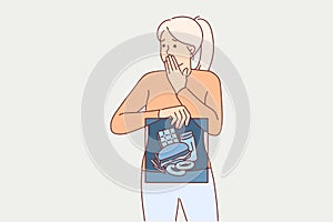 Junk food in stomach of woman holding x-ray and fearfully covering mouth with hand