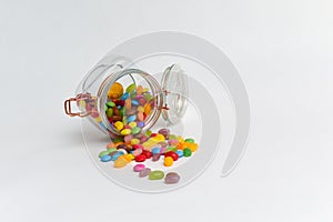 Junk food sweets and chocolate candy in a jar isolated