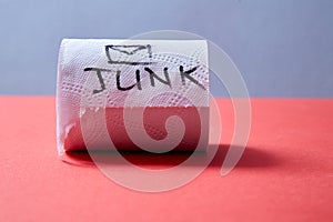 Junk mail or spam e-mail and unsolicited letter idea. Roll of toilet paper with the inscription junk.