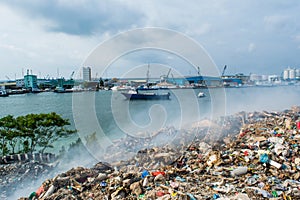 Junk yard area view full of smoke, litter, plastic bottles,rubbish and trash at the Thilafushi local tropical island