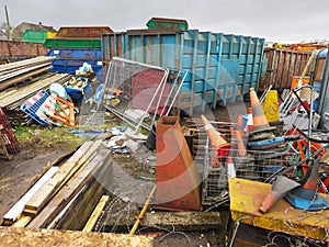 Junk yard and steel container with scrap metal, wood and traffic cones