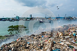 Junk yard zone view full of smoke, litter, plastic bottles,rubbish and trash at the Thilafushi local tropical island