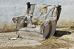 Junked, trashed and ruined upholstered chair ready to be taken to the landfill