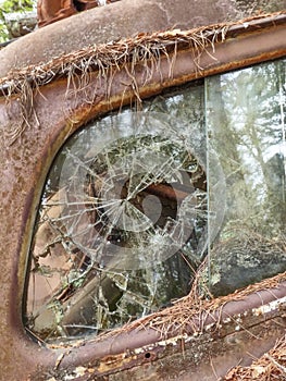 Junkyard abandoned rusty old car with broken window