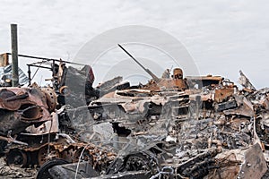 A junkyard of civilian cars and military equipment destroyed by explosions and fires