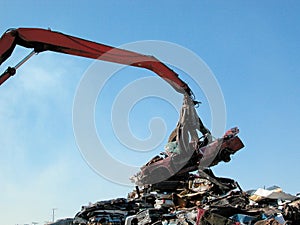 Junkyard crane with claw and crushed car