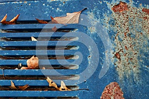 Junkyard rusty old abandoned car with turquoise grille in car graveyard