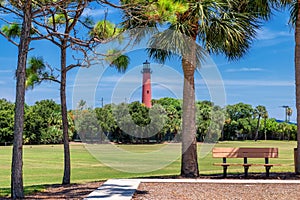 Jupiter lighthouse at sunny summer day and palm trees around, West Palm Beach, Florida